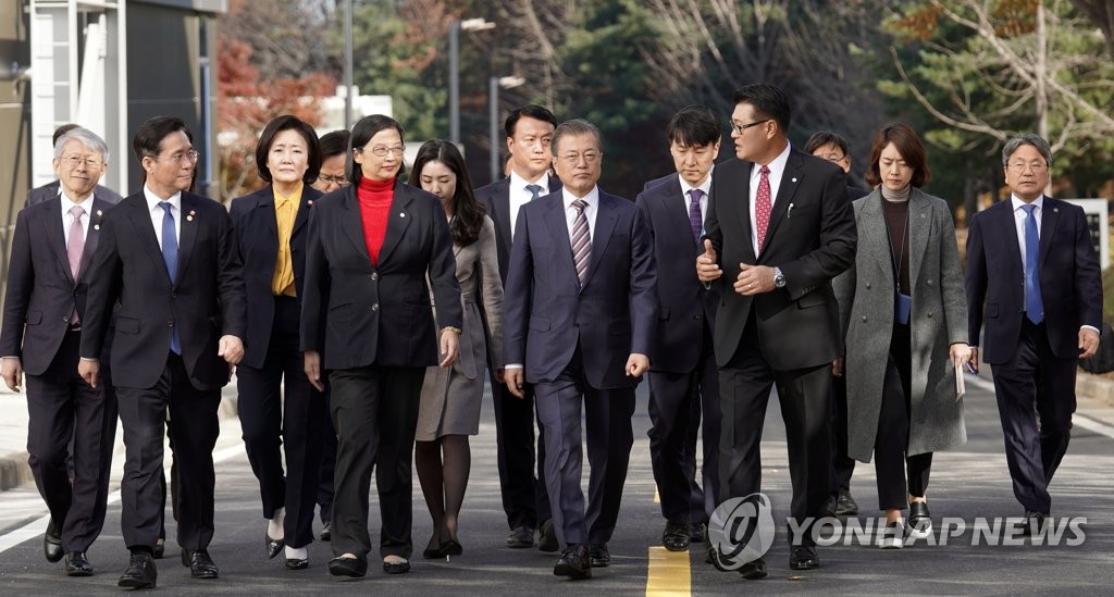 President Moon Jae-in (C) walks with Doris Hsu (4th from L), chairman and CEO of GlobalWafers Co., and other officials at a silicon wafer plant of MEMC Korea Co. in Cheonan, South Chungcheong Province, on Nov. 22, 2019. (Yonhap)