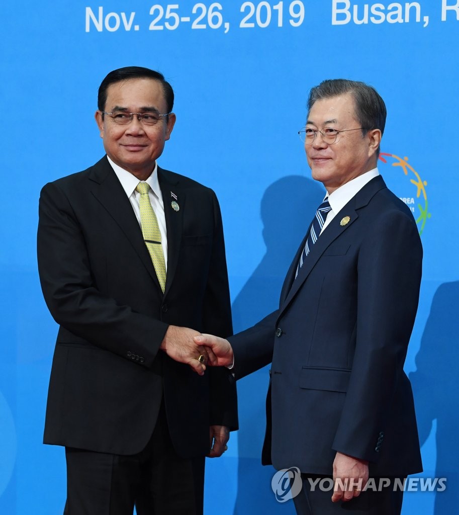 South Korea's President Moon Jae-in (R) shakes hands with Thailand's Prime Minister Prayut Chan-o-cha at the BEXCO convention center in Busan on Nov. 26, 2019. (Yonhap)