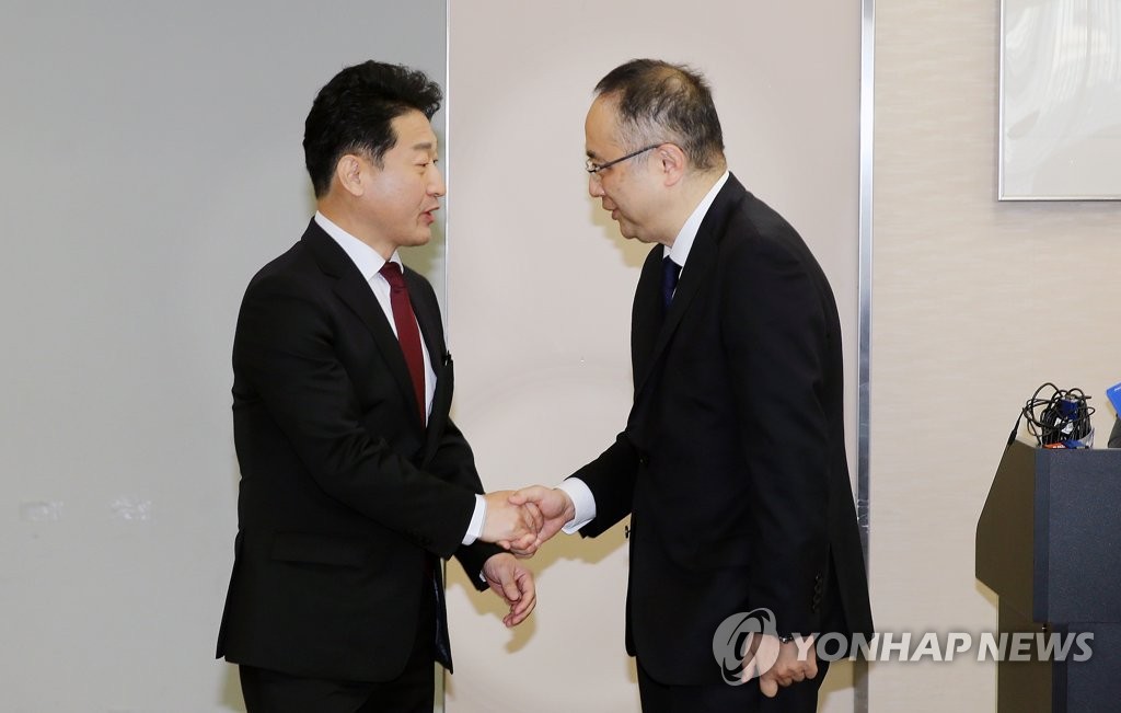 Lee Ho-hyeon (L), South Korea's director general for international trade policy, shakes hands with his Japanese counterpart, Yoichi Iida, ahead of a meeting on export controls in Tokyo on Dec. 16, 2019, in this photo released by the Ministry of Trade, Industry and Energy. (PHOTO NOT FOR SALE) (Yonhap)