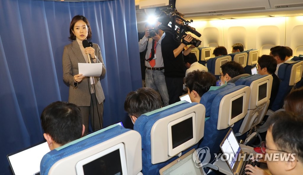 Cheong Wa Dae spokesperson Ko Min-jung (L, standing) holds an in-flight press briefing on the results of a summit between South Korean President Moon Jae-in and Chinese President Xi Jinping in Beijing on Dec. 23, 2019. (Yonhap)