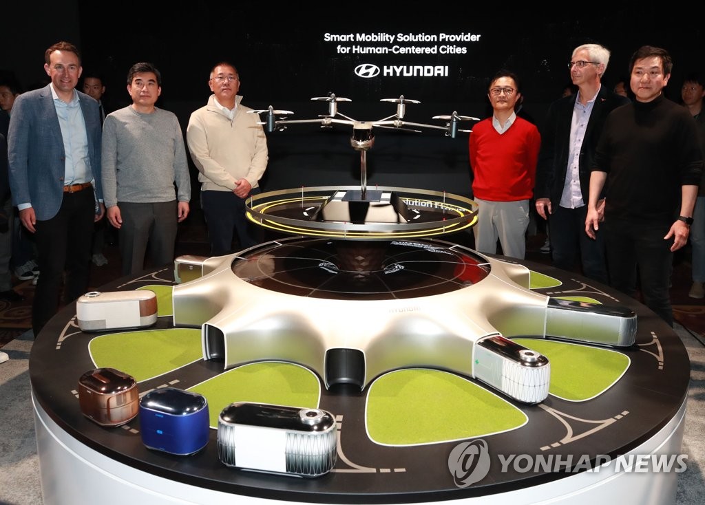 In this photo taken on Jan. 7, 2020 (local time), and provided by Hyundai Motor, Hyundai Motor Group Executive Vice Chairman Chung Euisun (3rd from left) and Eric Allison, head of Uber's air taxi service Uber Elevate (L), pose with other officials behind the 'S-A1' PAV concept jointly developed by Hyundai and Uber at a CES media day held at Mandalay Bay Hotel in Las Vegas. (Yonhap) 