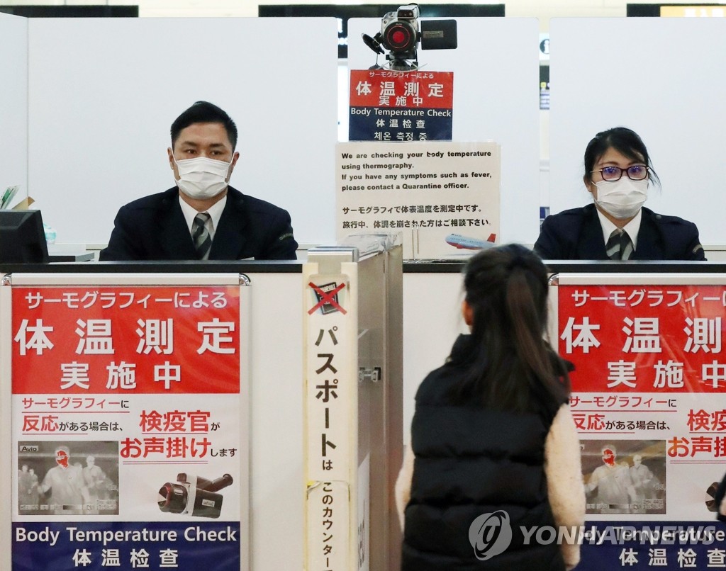 (나리타 EPA=연합뉴스) 일본 나리타 공항에서 당국자가 여행자의 체온을 감시하고 있다.