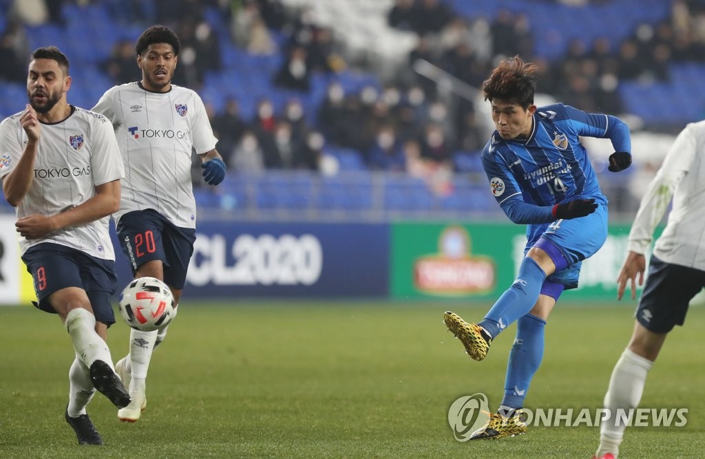 In this file photo from Feb. 11, 2020, Lee Dong-geong of Ulsan Hyundai FC (R) takes a shot against FC Tokyo during their Group F match at the Asian Football Confederation Champions League at Ulsan Munsu Football Stadium in Ulsan, 415 kilometers southeast of Seoul. (Yonhap)