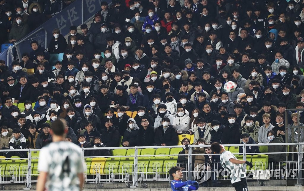 This file photo from Feb. 19, 2020, shows mask-wearing fans attending an Asian Football Confederation (AFC) Champions League match between the home team Suwon Samsung Bluewings and Vissel Kobe at Suwon World Cup Stadium in Suwon, 45 kilometers south of Seoul. (Yonhap)