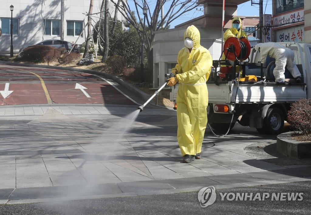 A quarantine staff member carries out a disinfection operation near an apartment building in the southern port city of Ulsan on Feb. 23, 2020, after a patient infected with the new coronavirus visited there. (Yonhap)
