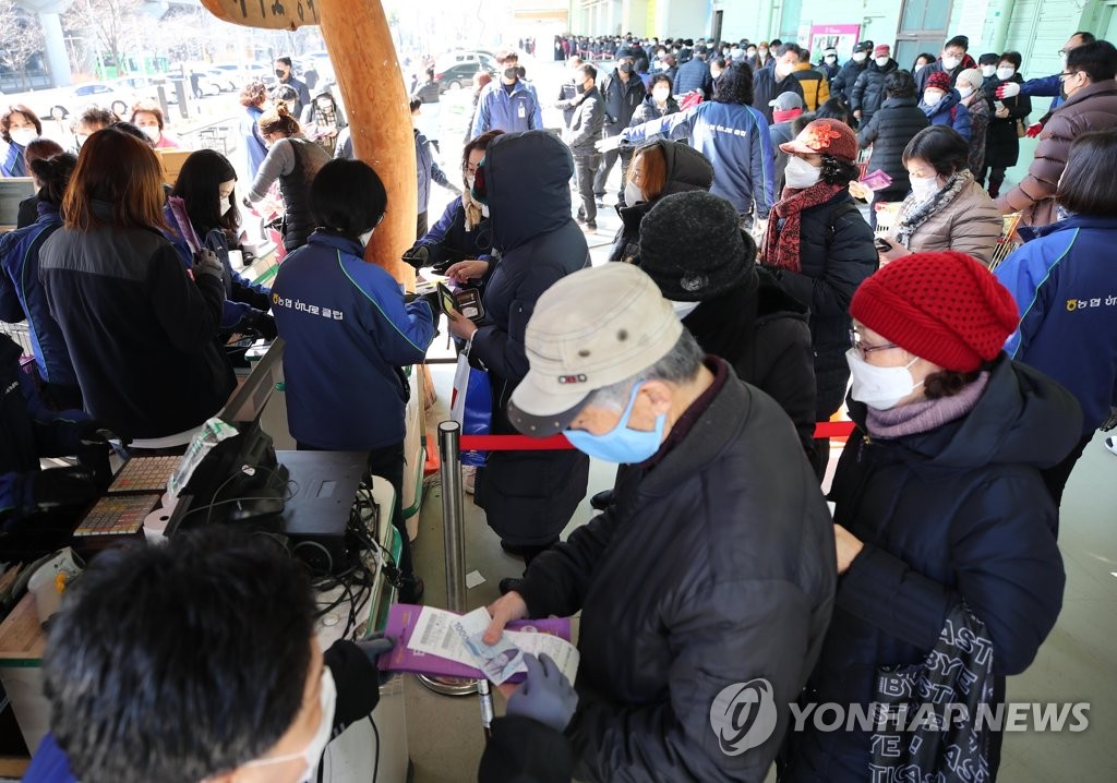 スーパーの農協ハナロマートが販売するマスクに列を作る人々＝５日、ソウル（聯合ニュース）