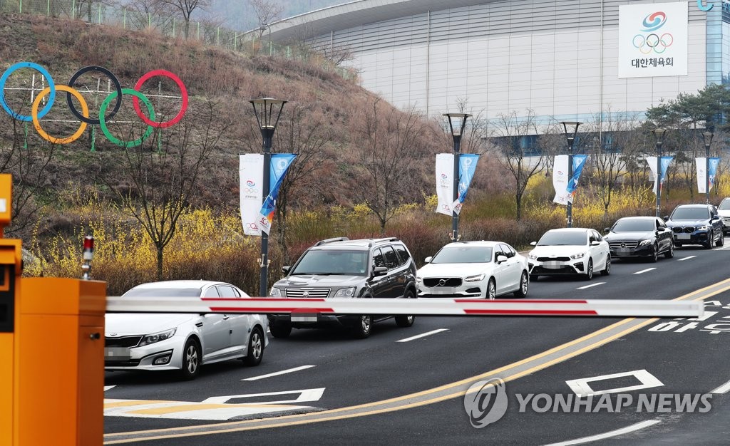 In this file photo, from March 27, 2020, vehicles line up near the exit of the Jincheon National Training Center in Jincheon, 90 kilometers south of Seoul, as athletes and coaches move out of the facility following the postponement of the Tokyo Olympics. (Yonhap)