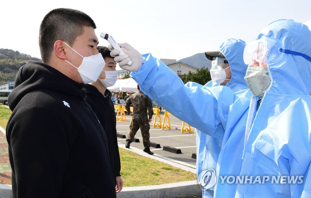 In this photo, provided by the Navy, officials conduct temperature checks on enlistees in the southeastern city of Changwon on March 30, 2020. (PHOTO NOT FOR SALE) (Yonhap) 