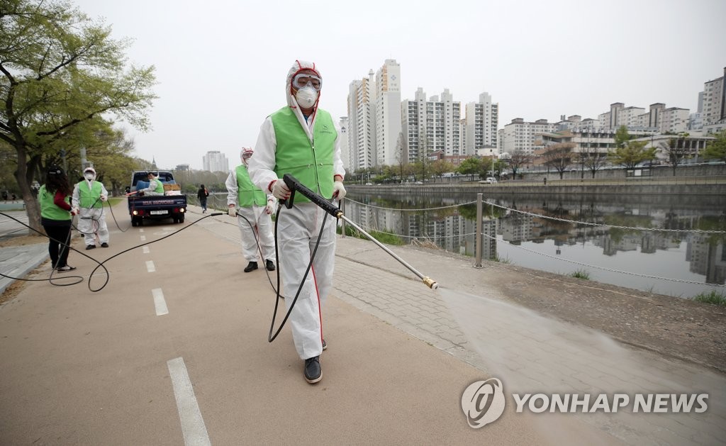 Health workers disinfect a street in Daegu on April 11, 2020. (Yonhap)