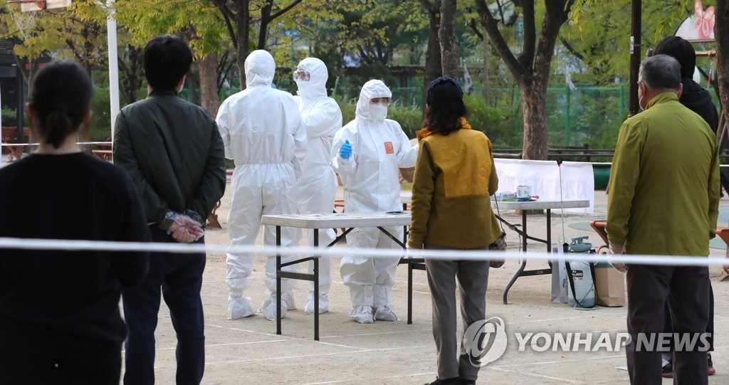 Voters subject to self-quarantine measures wait to cast their ballots at a polling station set up at a park in eastern Seoul on April 15, 2020. (Yonhap)