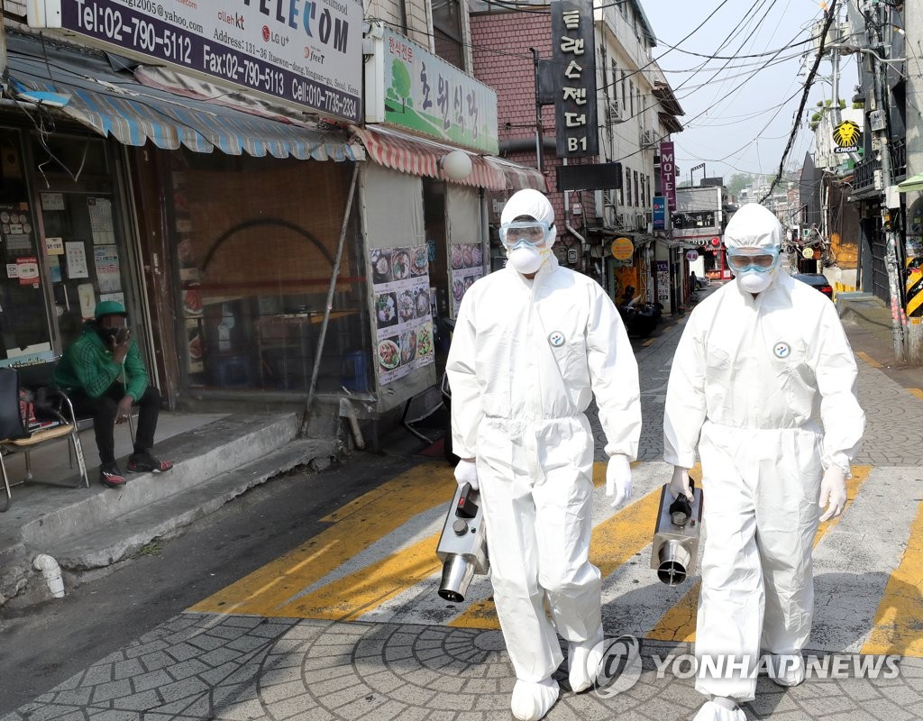 Quarantine workers carry out a disinfection operation in Seoul's popular multicultural neighborhood of Itaewon on May 11, 2020. (Yonhap)