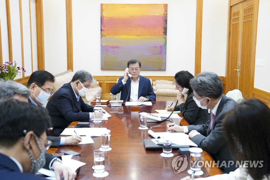 South Korean President Moon Jae-in (C) speaks with Chinese President Xi Jinping by phone at his office, with his aides listening in, on May 13, 2020, in this photo provided by Cheong Wa Dae. (PHOTO NOT FOR SALE) (Yonhap)