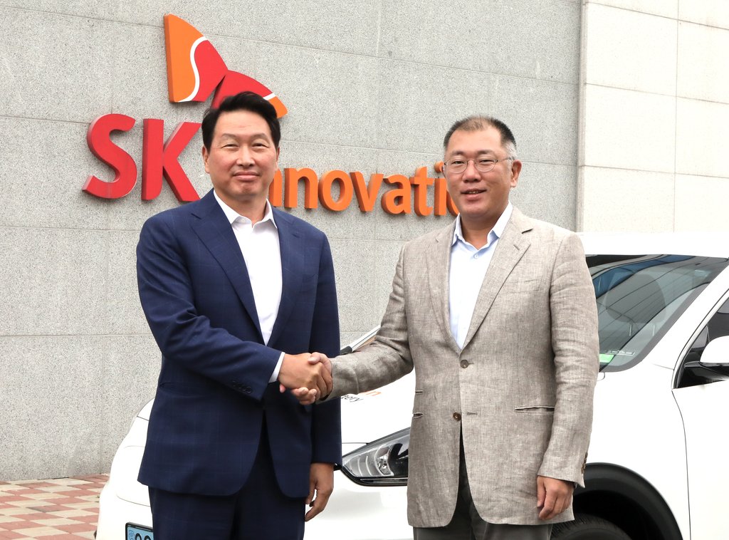 In this photo taken on July 7, 2020 and provided by Hyundai Motor Group, the group's Executive Vice Chairman Chung Euisun (R) shakes hands with SK Group Chairman Chey Tae-won at SK Innovation's car battery plant in Seosan, 150 kilometers south of Seoul. (PHOTO NOT FOR SALE) (Yonhap)