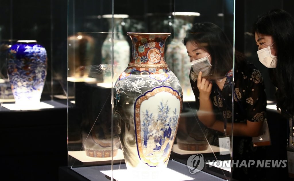 Visitors at the National Palace Museum of Korea in Seoul on July 28, 2020, observe a Chinese-made porcelain vase that was exported to France and later brought to Korea during the late 19th century. The vase is part of the museum's exhibition on ceramics previously owned by the Joseon royal court. (Yonhap)