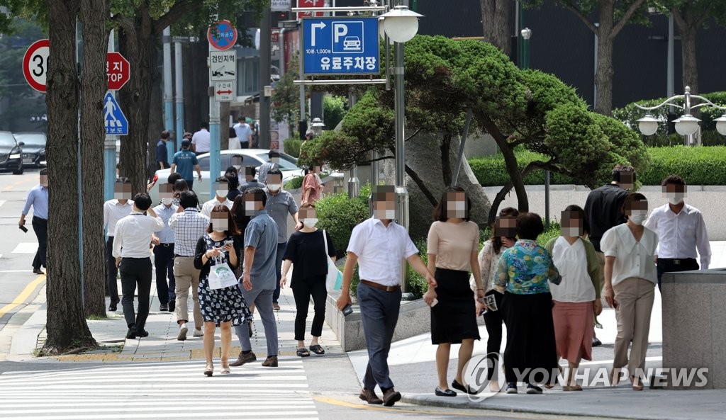 Citizens wearing protective masks walk on a street in central Seoul on Aug. 18, 2020. (Yonhap)