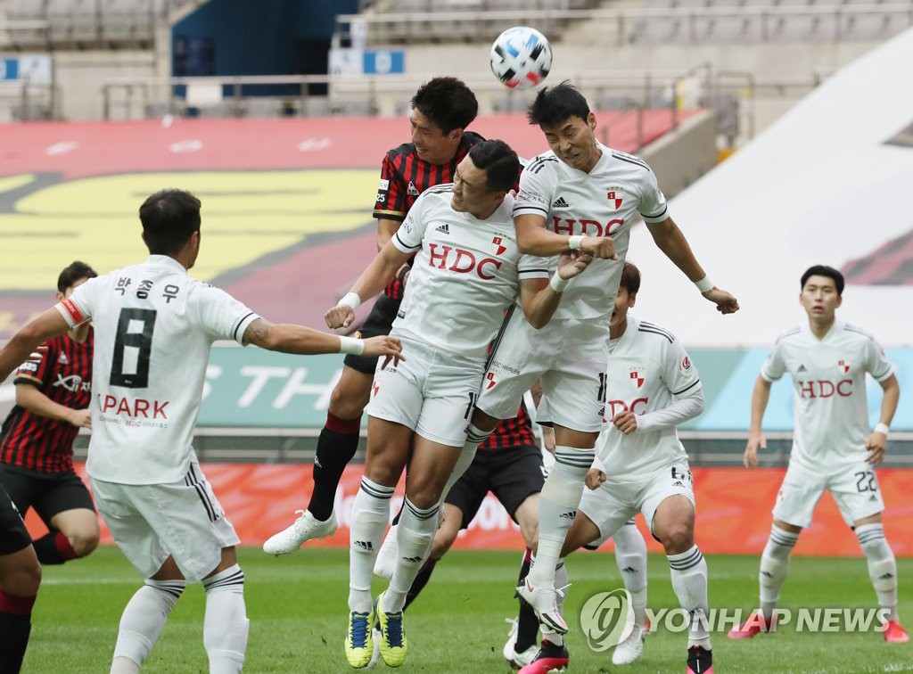 In this file photo from Oct. 4, 2020, players for Busan IPark (white) and FC Seoul battle for a loose ball during their K League 1 match at Seoul World Cup Stadium in Seoul. (Yonhap)
