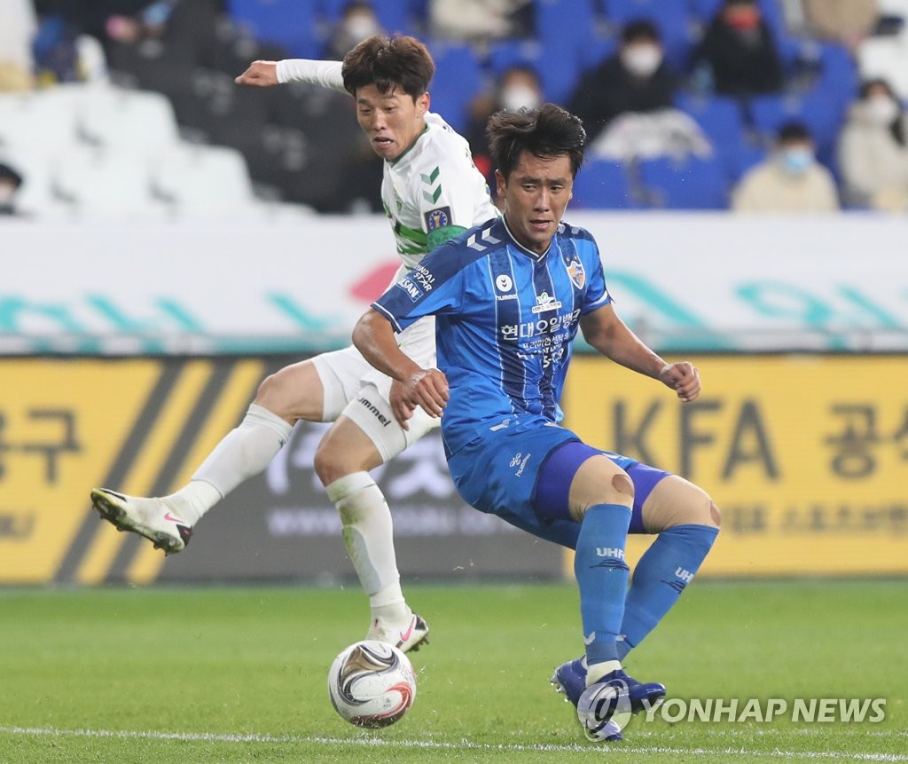 Won Du-jae of Ulsan Hyundai FC (R) blocks a shot by Kim Bo-kyung of Jeonbuk Hyundai Motors during the first leg of the FA Cup final at Ulsan Munsu Football Stadium in Ulsan, 415 kilometers southeast of Seoul, on Nov. 4, 2020. (Yonhap)