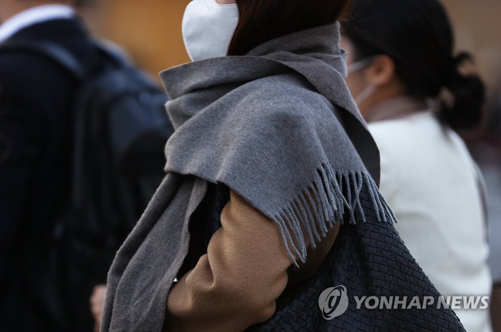 A commuter wearing a protective mask walks near Gwanghwamun Square in central Seoul on Nov. 9, 2020. (Yonhap)