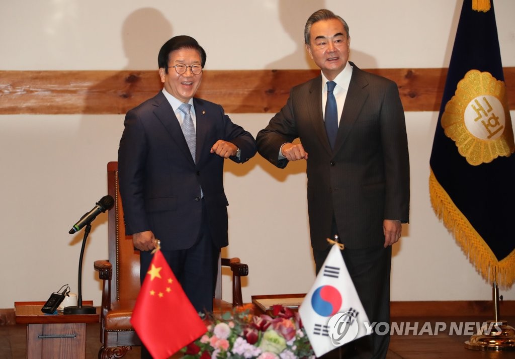 South Korean Parliamentary Speaker Park Byeong-seug (L) and Chinese Foreign Minister Wang Yi bump elbows before they begin talks in Seoul on Nov. 27, 2020. (Yonhap)