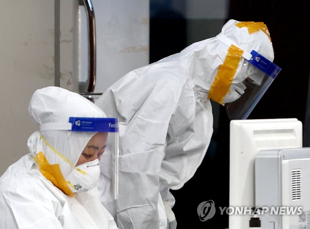 ソウル・松坡区保健所の専用診療所に詰めている医療関係者。防護服のすき間にテープを張り付けている＝３日、ソウル（聯合ニュース）