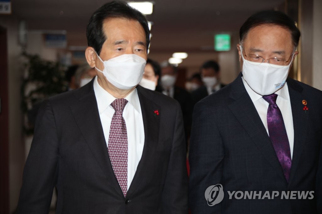 Prime Minister Chung Sye-kyun (L) and Finance Minister Hong Nam-ki arrive at a vaccine procurement-related government meeting held at the government complex in Seoul on Dec. 15, 2020. (Yonhap)