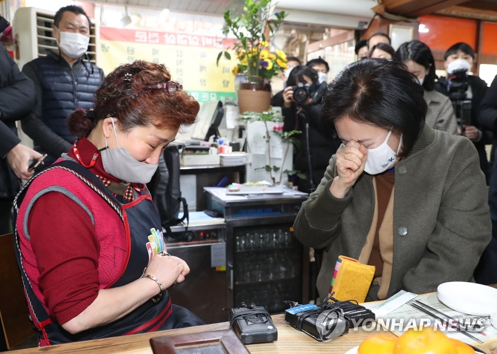 SMEs and Startups Minister Park Young-sun (R) breaks into tears while listening to stories of small business owners' economic hardships at a traditional market in northeastern Seoul on Jan. 14, 2021. (Yonhap)