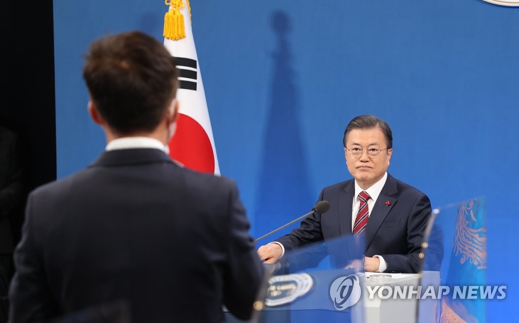 President Moon Jae-in (R) listens to a reporter's question during a New Year's press conference at the presidential office Cheong Wa Dae in Seoul on Jan. 18, 2021. (Yonhap)