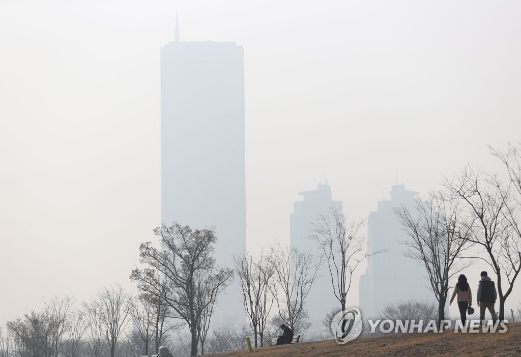 Citizens walk at a riverside park in Seoul on March 11, 2021, as the capital city is shrouded in fine dust air pollution. (Yonhap)