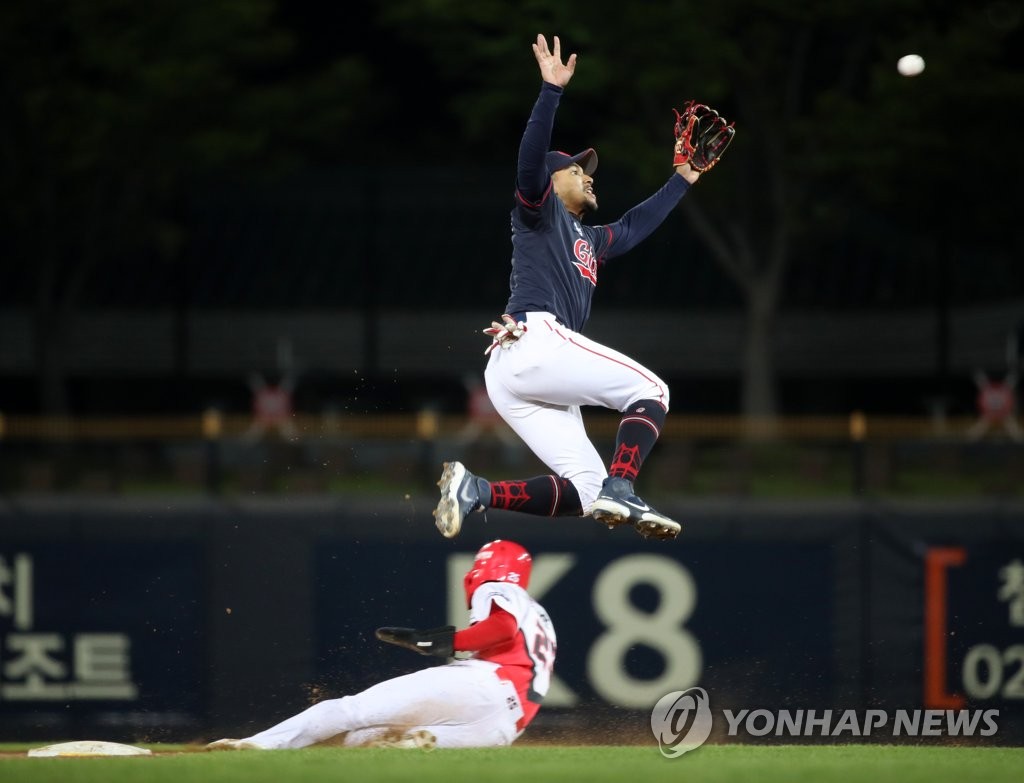 In this file photo from April 15, 2021, Lotte Giants' shortstop Dixon Machado (R) tries to make a leaping grab on a throw as Park Chan-ho of the Kia Tigers steals second base during the bottom of the seventh inning of a Korea Baseball Organization regular season game at Gwangju-Kia Champions Field in Gwangju, 330 kilometers south of Seoul. (Yonhap)
