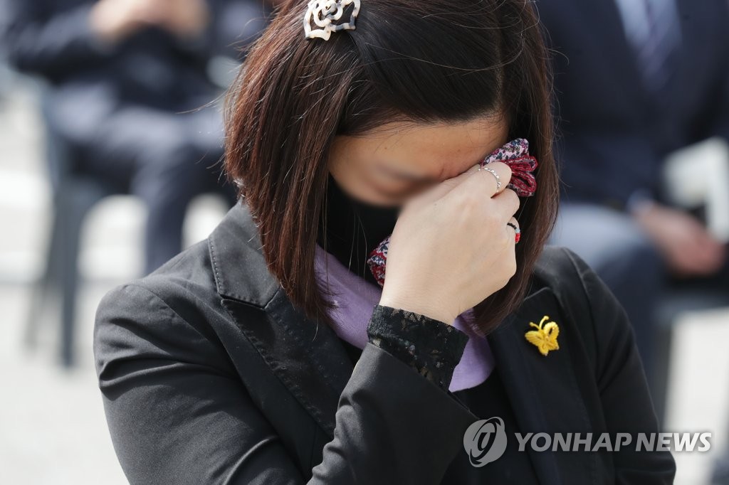 4月16日，在京畿道安山市花郎游乐园，出席“世越”号沉船事故遇难者悼念仪式的市民忍不住流泪。 韩联社