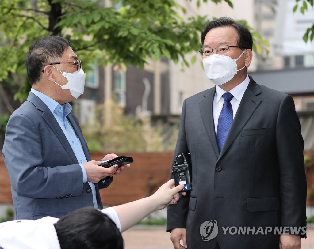 Kim Boo-kyum (R), the nominee for prime minister, answers reporters' questions upon arriving at his temporary office in Seoul on April 30, 2021. (Yonhap)