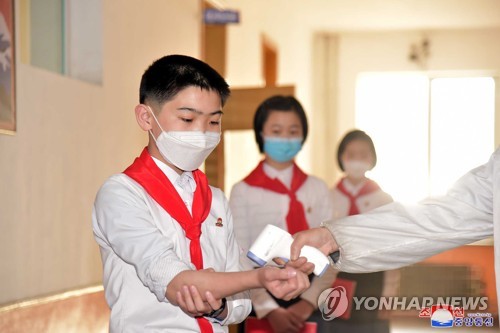 복도에서 마스크 쓰고 체온 재는 북한 중학생들