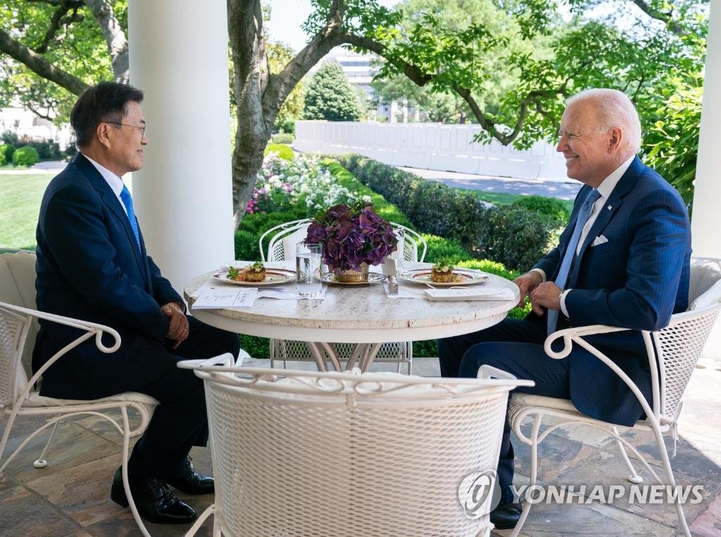 South Korean President Moon Jae-in (L) and U.S. President Joe Biden hold a one-on-one meeting over lunch in Washington on May 21, 2021, in this photo captured from Biden's Twitter account. Maryland crab cakes were served as the main course, according to Moon's office. (PHOTO NOT FOR SALE) (Yonhap)