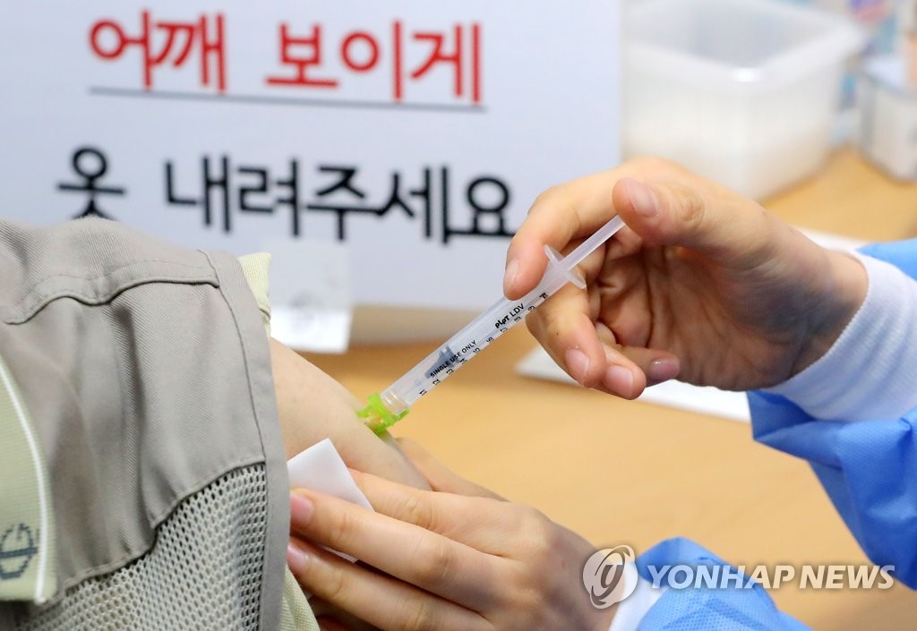 A health worker gives a COVID-19 vaccine shot at an inoculation center in Seoul on June 12, 2021. (Yonhap)