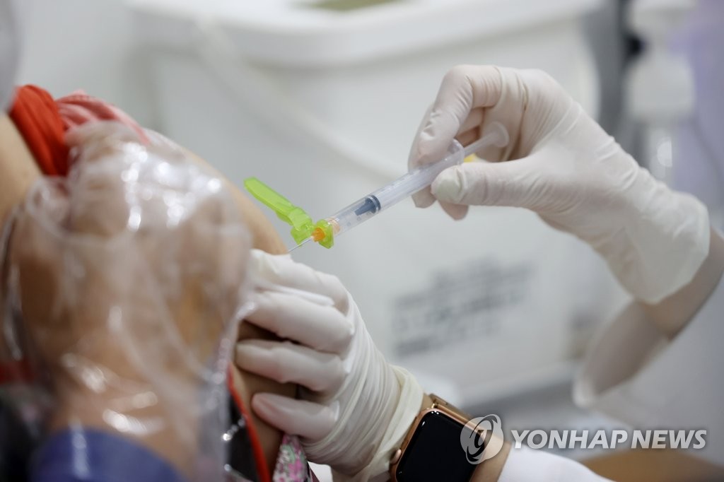 A health worker gives a COVID-19 vaccine shot to a senior citizen at a vaccination center in Seoul on June 17, 2021. (Yonhap)