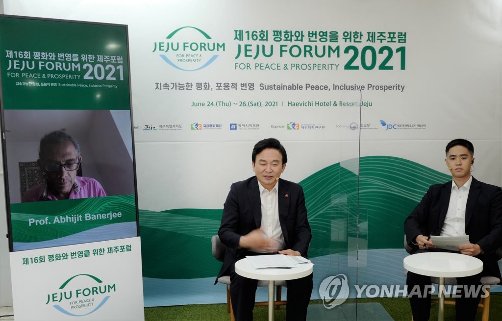 Le gouverneur de Jeju Won Hee-ryong (à g.) s'entretient avec Prix Nobel d'économie Abhijit Banerjee, professeur au Massachusetts Institute of Technology (MIT), via une liaison vidéo lors d'une séance de pré-ouverture du Forum de Jeju pour la paix et la prospérité, le 21 juin 2021. (Photo fournie par le Forum de Jeju. Revente et archivage interdits)