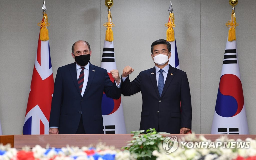 Defense Minister Suh Wook (R) and his British counterpart, Ben Wallace, pose for a photo during a meeting in Seoul on July 21, 2021, in this photo provided by the Kookbang Ilbo newspaper. (PHOTO NOT FOR SALE) (Yonhap)