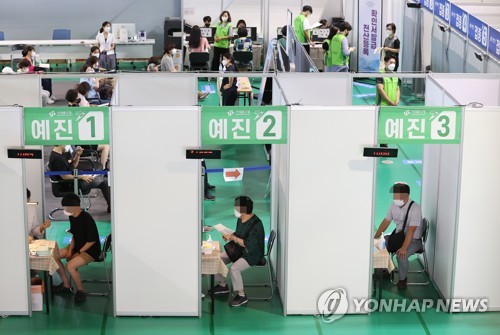 People wait for their turn for COVID-19 vaccine shots at a vaccination center in western Seoul on July 22, 2021. (Yonhap)
