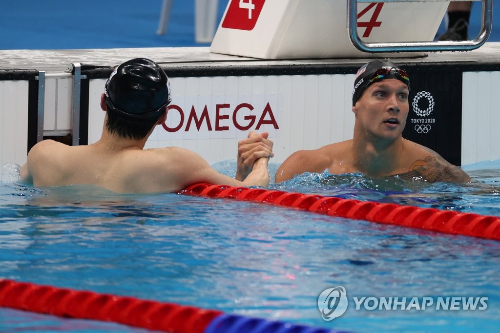 Hwang Sun-woo of South Korea (L) shakes hands with Caeleb Dressel of the United States after finishing his semifinals race in the men's 100m freestyle swimming at the Tokyo Olympics at Tokyo Aquatics Centre in Tokyo on July 28, 2021. (Yonhap)