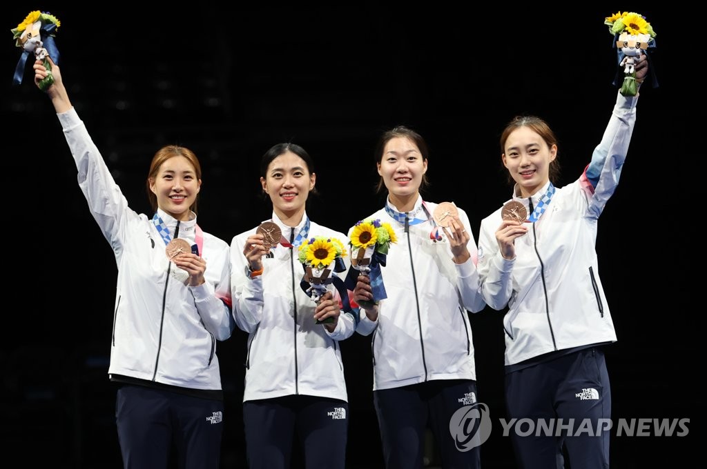 South Korean fencers Choi Soo-yeon, Kim Ji-yeon, Seo Ji-yeon and Yoon Ji-su (L to R) pose for a photo on the podium after winning the bronze medal in the women's sabre team fencing event at the Tokyo Olympics at Makuhari Messe Hall B in Chiba, Japan, on July 31, 2021. (Yonhap)