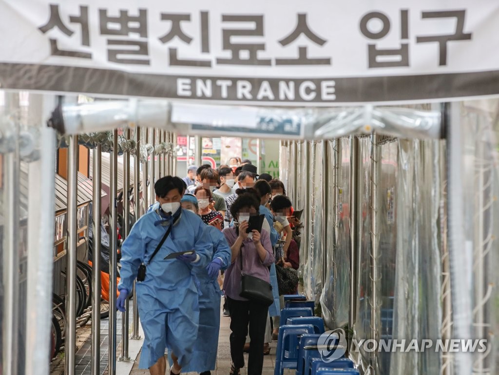 ソウル市冠岳区内の保健所の検査所を訪れた市民が、関係者の案内に従って移動している＝１１日、ソウル（聯合ニュース）