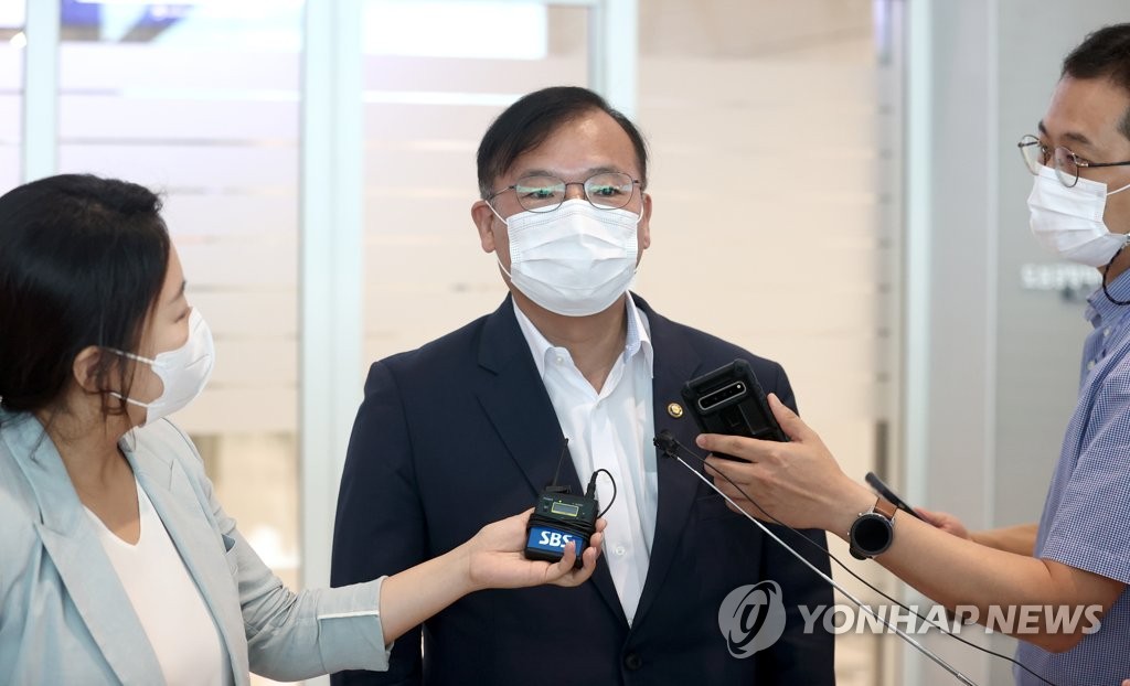 仁川国際空港で記者団の質問に答える姜氏＝１３日、仁川（聯合ニュース）
