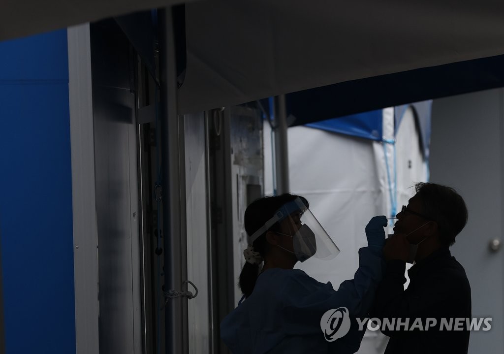 A medical worker collects a swab sample for a coronavirus test at a screening center in northern Seoul on Sept. 2, 2021. (Yonhap)