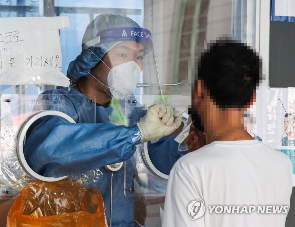 A medical worker collects a swab sample for a coronavirus test at a screening center in central Seoul on Sept. 3, 2021. (Yonhap) 