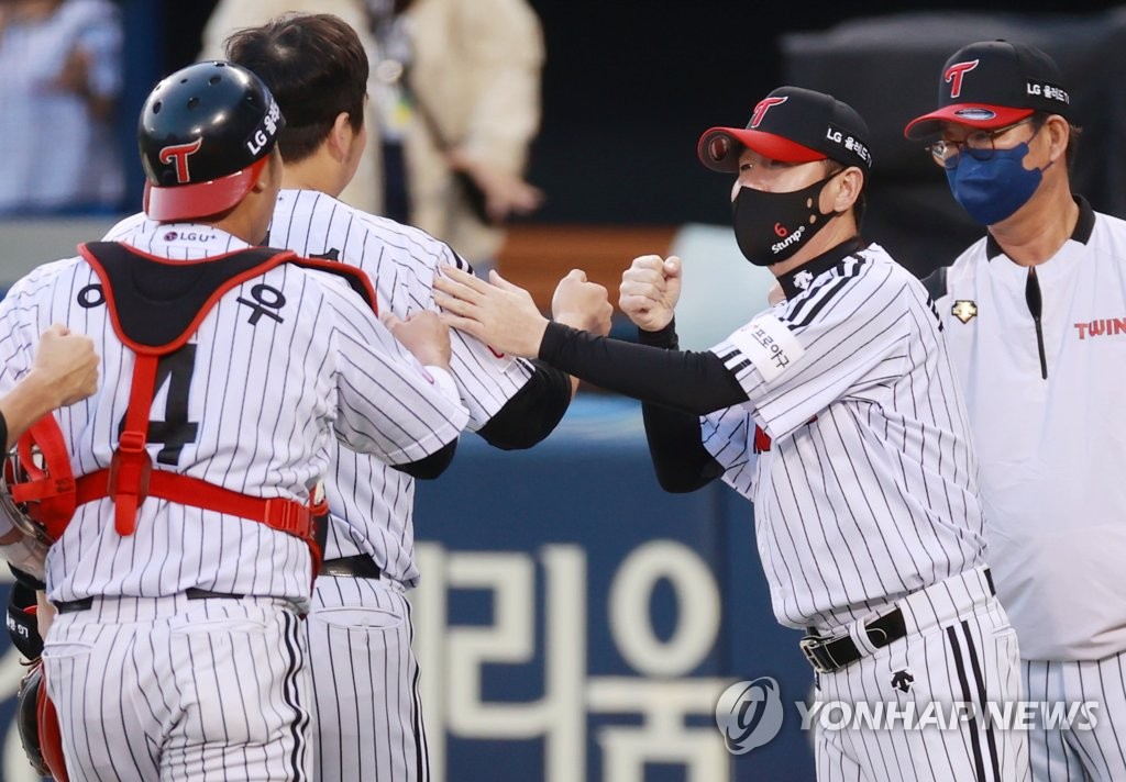 In this file photo from Oct. 6, 2021, LG Twins manager Ryu Ji-hyun (R) bumps fists with outfielder Kim Hyun-soo after the Twins' 4-1 victory over the SSG Landers in a Korea Baseball Organization regular season game at Jamsil Baseball Stadium in Seoul. (Yonhap)