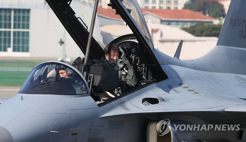 President Moon Jae-in (R), wearing a pilot uniform, arrives aboard a South Korean-made FA-50 jet fighter at Seoul Air Base in Seongnam, south of Seoul, on Oct. 20, 2021, to attend the opening ceremony of the Seoul International Aerospace & Defense Exhibition, a biennial defense exhibition that offers an in-depth look at state-of-the-art military hardware. (Yonhap)