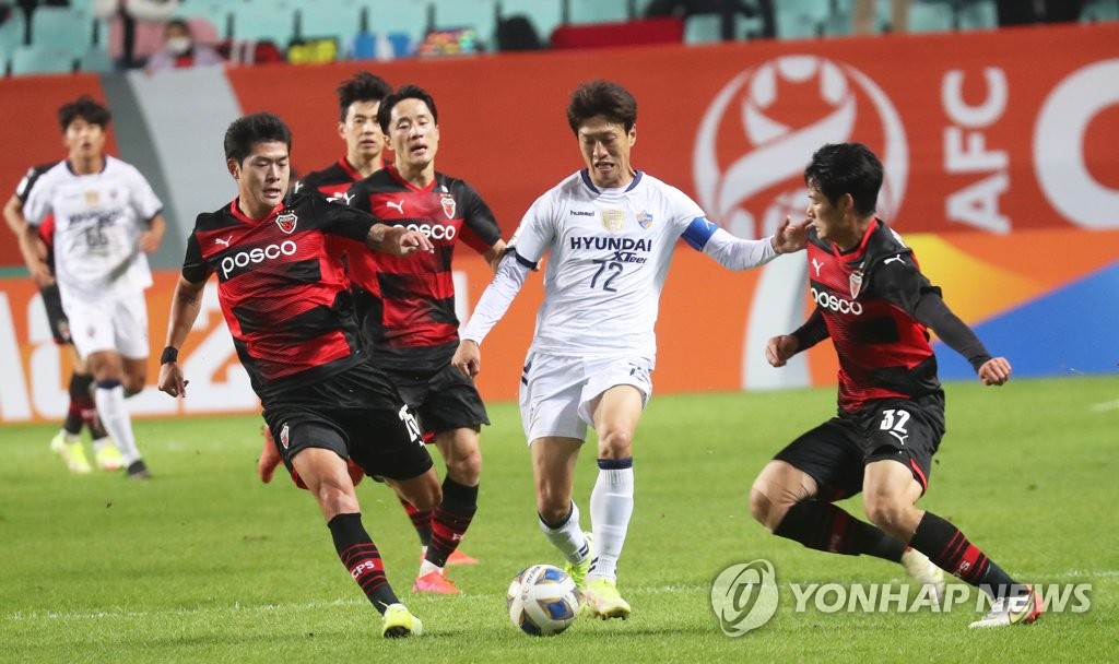 Lee Chung-yong of Ulsan Hyundai FC (C) tries to dribble past Pohang Steelers defenders during the semifinals of the Asian Football Confederation Champions League at Jeonju World Cup Stadium in Jeonju, some 240 kilometers south of Seoul, on Oct. 20, 2021. (Yonhap)