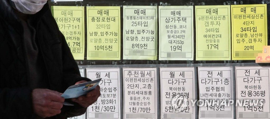  서울 서대문구의 부동산 중개업소에 게시된 매물 가격 안내판 앞