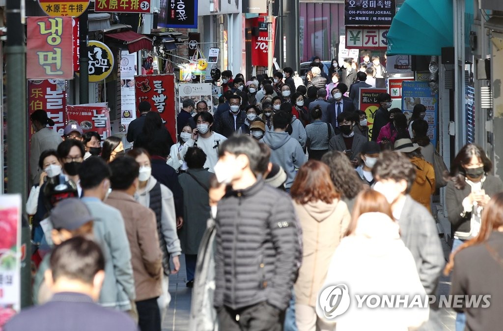 This photo, taken Oct. 25, 2021, shows people at the shopping district of Myeongdong in downtown Seoul as South Korea plans to gradually return to normal life starting next month with eased virus restrictions. (Yonhap)