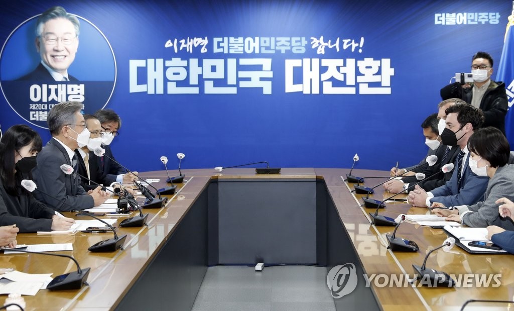 Lee Jae-myung (L), the presidential candidate of the ruling Democratic Party (DP), speaks with U.S. senator Jon Ossoff at the DP's headquarters in Seoul on Nov. 12, 2021. (Pool photo) (Yonhap)